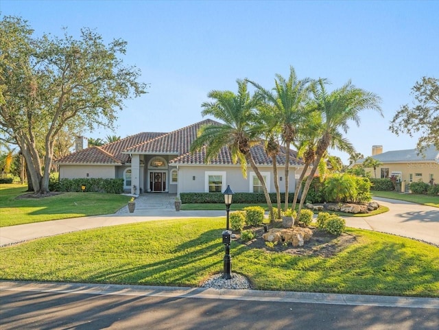 mediterranean / spanish-style house featuring a front lawn