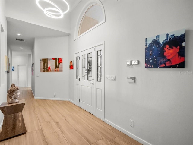 entrance foyer featuring a towering ceiling and light hardwood / wood-style floors