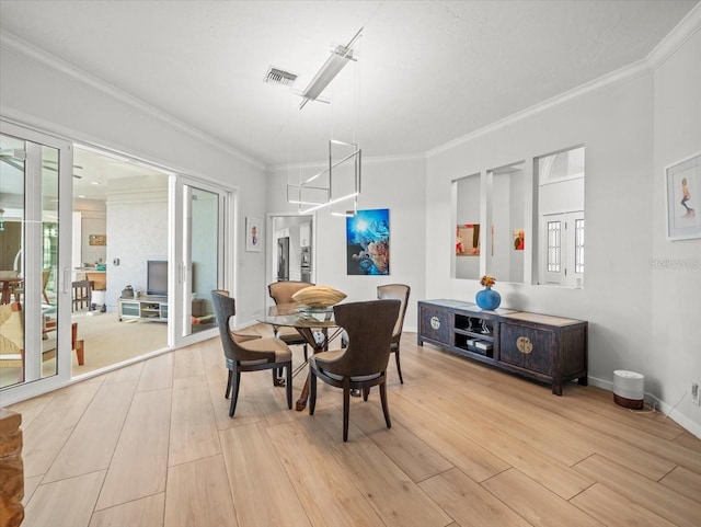 dining area with plenty of natural light, light hardwood / wood-style floors, and crown molding