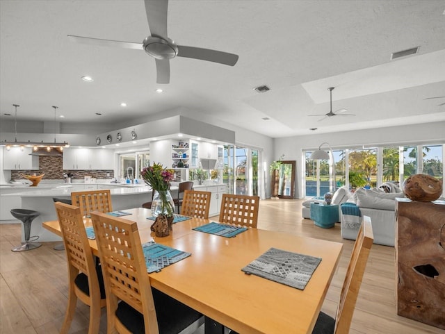 dining room with ceiling fan and light hardwood / wood-style flooring