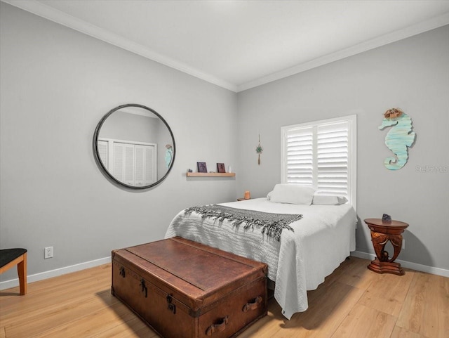 bedroom with light wood-type flooring and crown molding