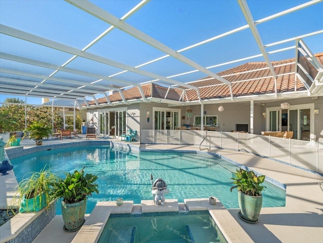 view of pool with glass enclosure and a patio area