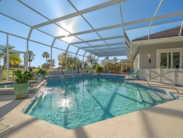 view of swimming pool with pool water feature, a patio area, and a lanai