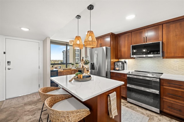 kitchen with a kitchen bar, appliances with stainless steel finishes, backsplash, pendant lighting, and a center island