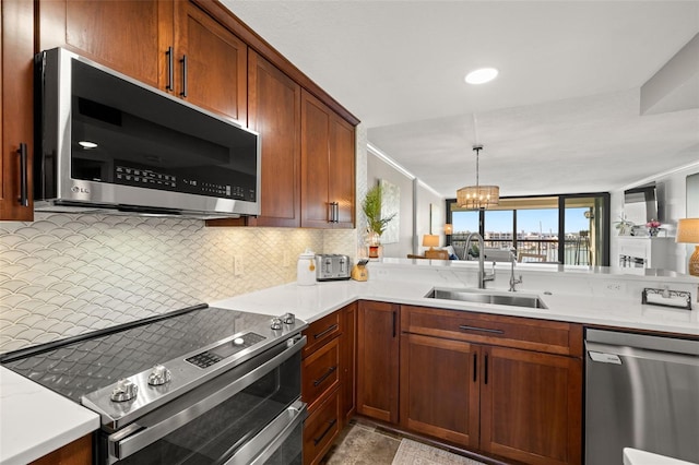 kitchen with pendant lighting, sink, decorative backsplash, appliances with stainless steel finishes, and a notable chandelier