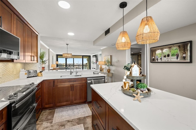 kitchen featuring tasteful backsplash, sink, stainless steel appliances, and decorative light fixtures