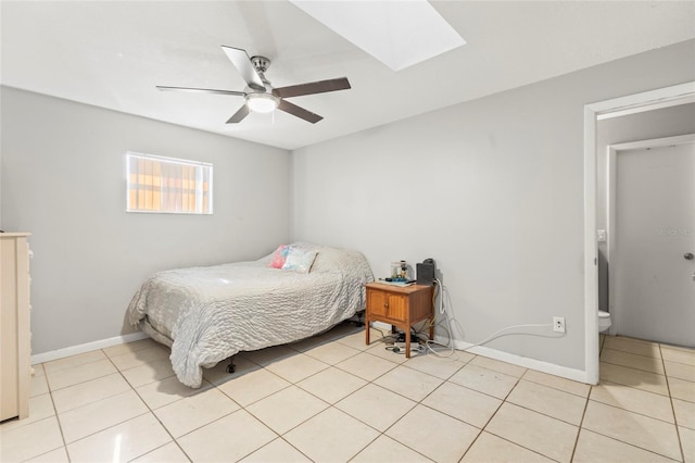 bedroom with ceiling fan, light tile patterned floors, and a skylight