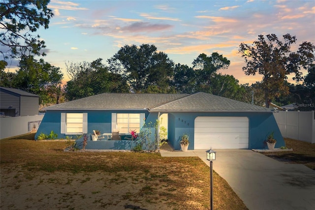 ranch-style house featuring a lawn and a garage