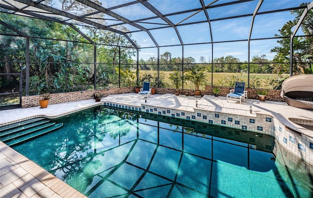 view of swimming pool with glass enclosure and a patio area