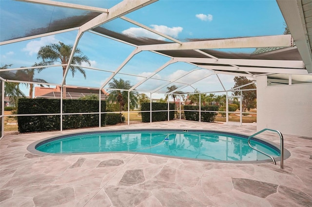 view of pool with glass enclosure and a patio