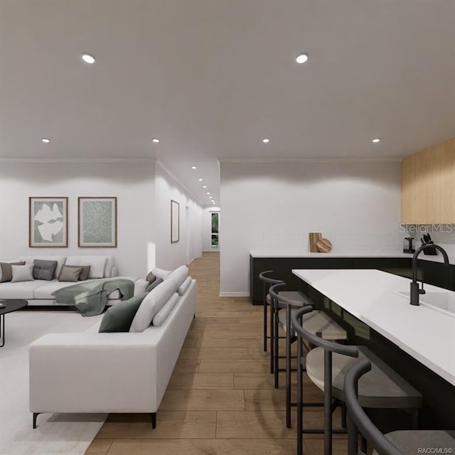 living room featuring light hardwood / wood-style floors, ornamental molding, and sink