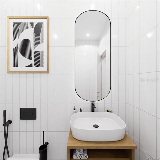 bathroom featuring sink and tile walls