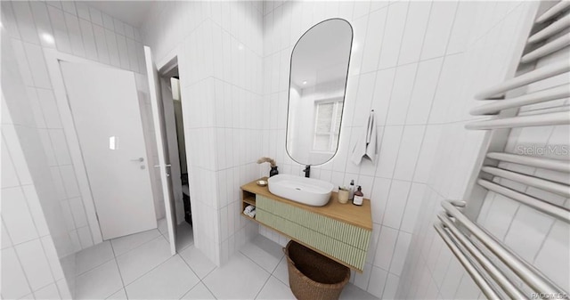 bathroom featuring tile patterned floors, radiator heating unit, vanity, and tile walls