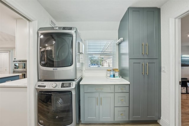 13945 75th Ave, Seminole, FL 33776 - clothes washing area with stacked washing machine and dryer, cabinet space, and wood finished floors