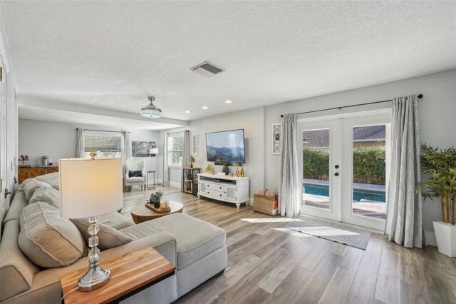 13945 75th Ave, Seminole, FL 33776 - living room featuring french doors, a textured ceiling, wood finished floors, and recessed lighting