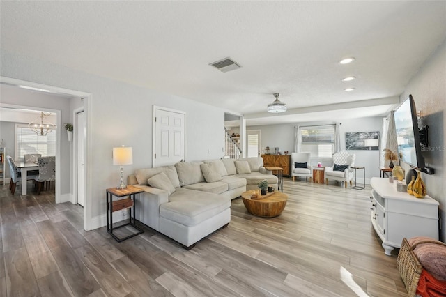 13945 75th Ave, Seminole, FL 33776 - living room featuring a chandelier, stairs, wood finished floors, healthy amount of natural light, and recessed lighting