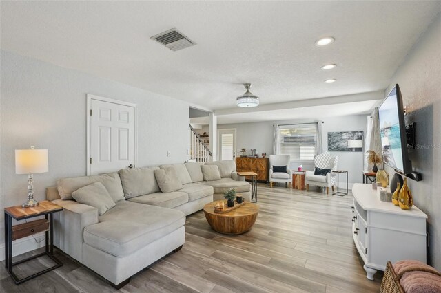 13945 75th Ave, Seminole, FL 33776 - living room featuring stairs, light wood-style flooring, and recessed lighting