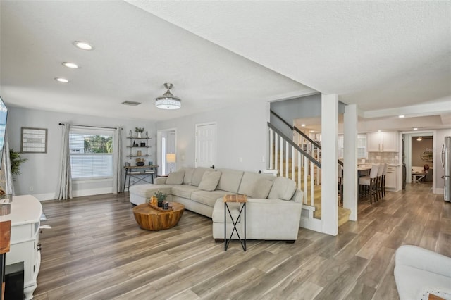 13945 75th Ave, Seminole, FL 33776 - living area with light wood-style floors, stairs, recessed lighting, baseboards, and a textured ceiling