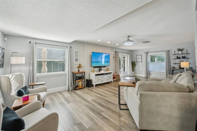 13945 75th Ave, Seminole, FL 33776 - living area featuring a textured ceiling, light wood-type flooring, baseboards, and recessed lighting