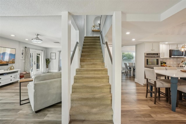13945 75th Ave, Seminole, FL 33776 - staircase with wood finished floors, recessed lighting, and a textured ceiling