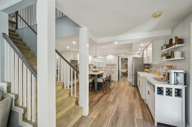 13945 75th Ave, Seminole, FL 33776 - bar featuring stairs, light wood-style flooring, decorative backsplash, freestanding refrigerator, and recessed lighting