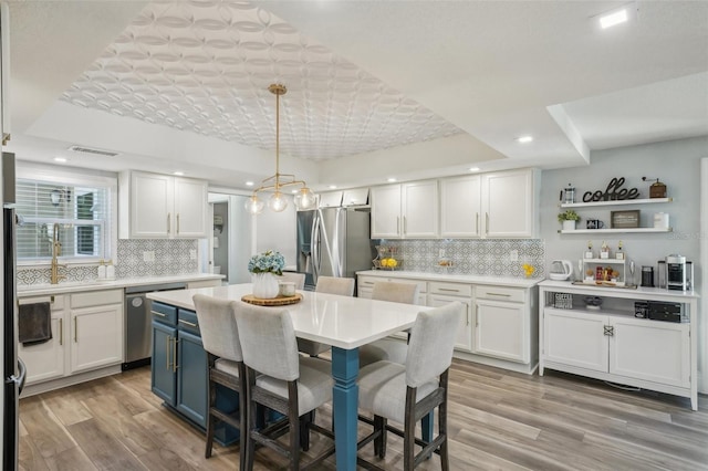 13945 75th Ave, Seminole, FL 33776 - kitchen featuring appliances with stainless steel finishes, white cabinets, light countertops, backsplash, and recessed lighting