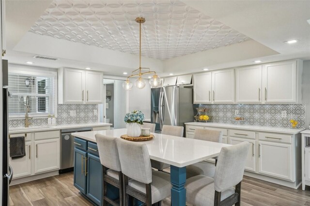 13945 75th Ave, Seminole, FL 33776 - kitchen featuring blue cabinets, stainless steel appliances, backsplash, white cabinetry, and recessed lighting