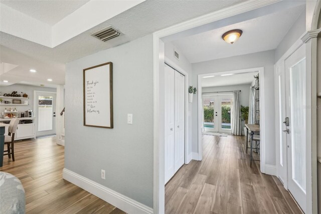 13945 75th Ave, Seminole, FL 33776 - hallway with baseboards, wood finished floors, french doors, and recessed lighting