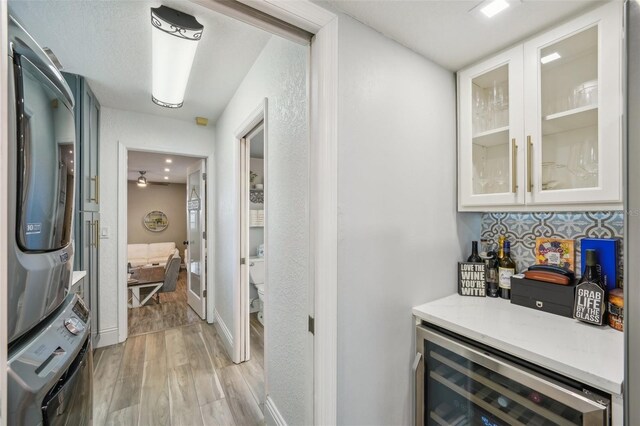 13945 75th Ave, Seminole, FL 33776 - hallway featuring stacked washer / drying machine, beverage cooler, and light wood finished floors