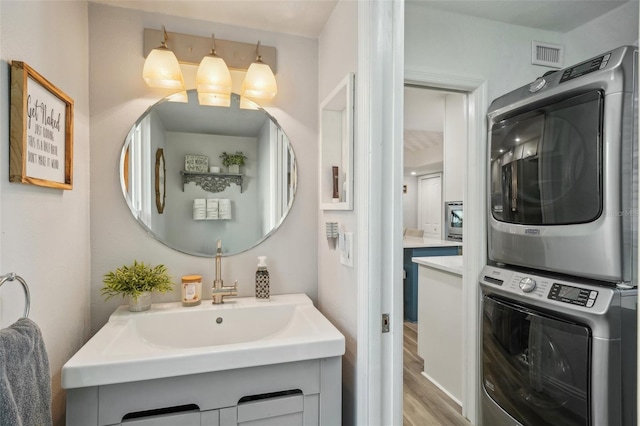 13945 75th Ave, Seminole, FL 33776 - bathroom with stacked washer / dryer, wood finished floors, and a sink