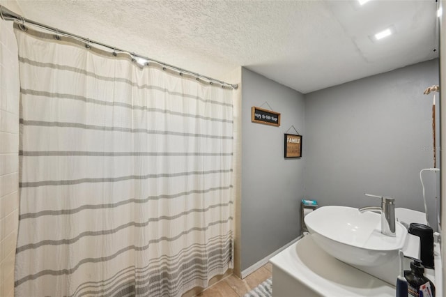 13945 75th Ave, Seminole, FL 33776 - bathroom with a sink, a textured ceiling, and a shower with shower curtain