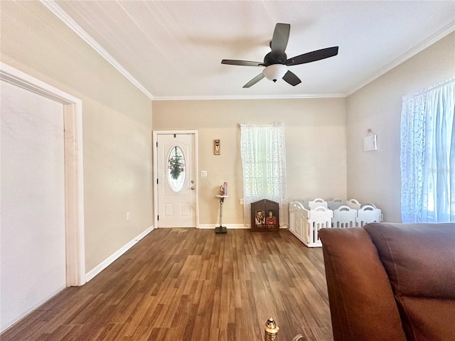 foyer with ceiling fan, dark wood-type flooring, and ornamental molding