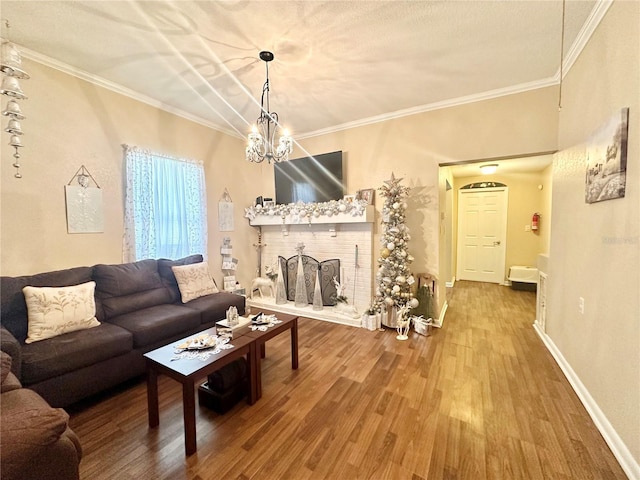 living room with crown molding, wood-type flooring, and a notable chandelier