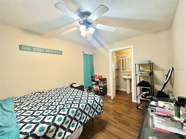 bedroom with hardwood / wood-style flooring, ceiling fan, a textured ceiling, and connected bathroom