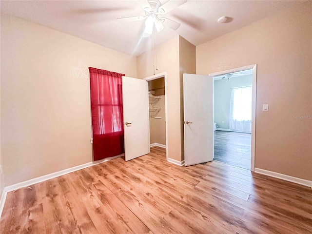 unfurnished bedroom with wood finished floors, ceiling fan, baseboards, and a closet