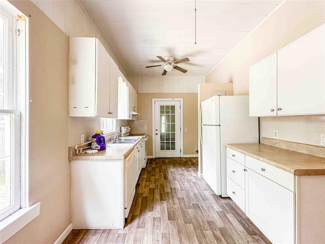 kitchen featuring light wood-type flooring, white appliances, and a healthy amount of sunlight