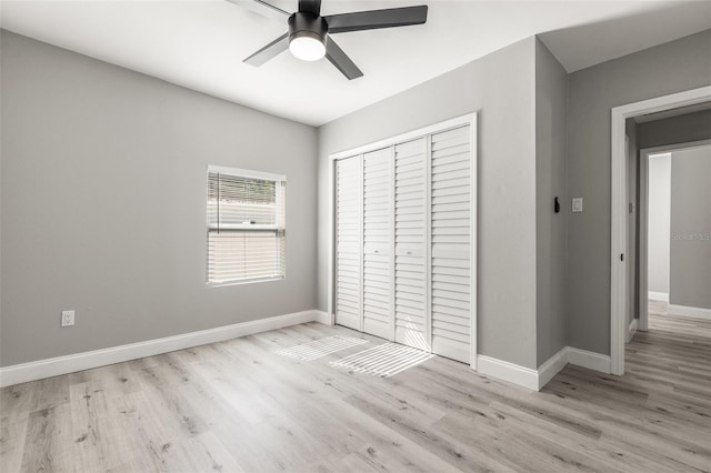 unfurnished bedroom featuring ceiling fan, a closet, and light wood-type flooring