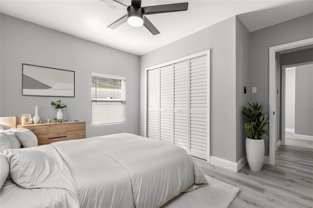 bedroom featuring ceiling fan, light hardwood / wood-style floors, and a closet