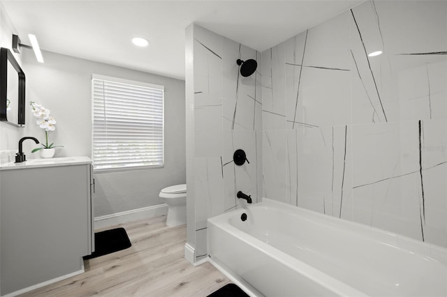 full bathroom featuring tiled shower / bath, vanity, toilet, and hardwood / wood-style floors