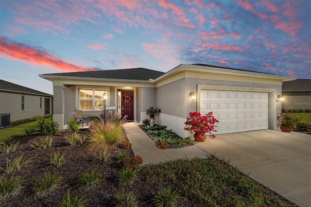 view of front of home with a garage and central air condition unit