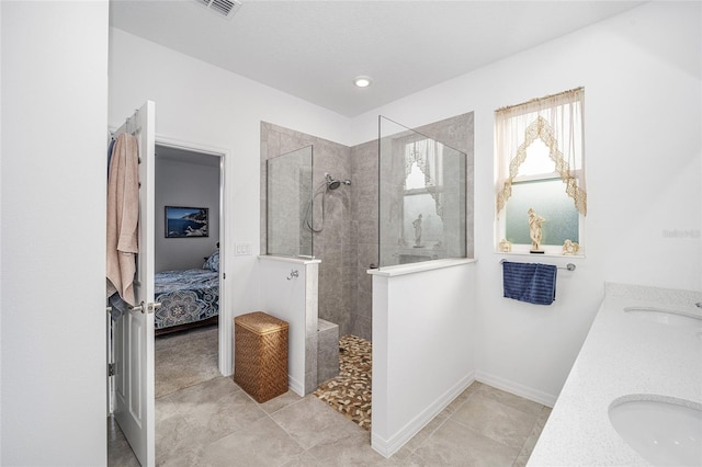 bathroom featuring vanity and tiled shower