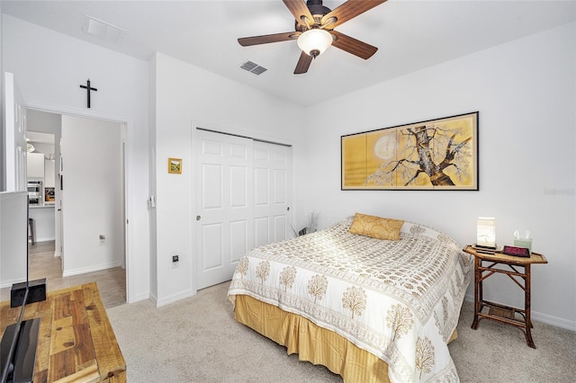 carpeted bedroom with ceiling fan and a closet