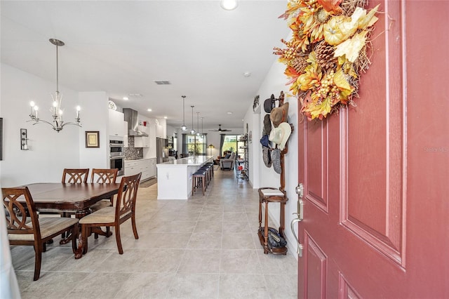 tiled dining space with an inviting chandelier