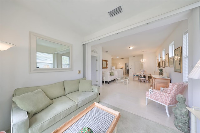 living room featuring light colored carpet and a notable chandelier