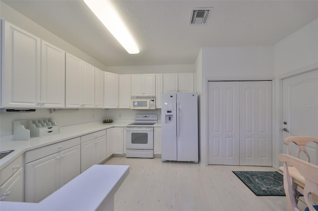 kitchen featuring white cabinets and white appliances