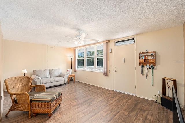 living room with hardwood / wood-style floors, ceiling fan, and a textured ceiling