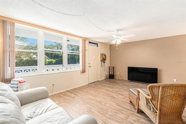 living room featuring a textured ceiling, light hardwood / wood-style flooring, plenty of natural light, and ceiling fan