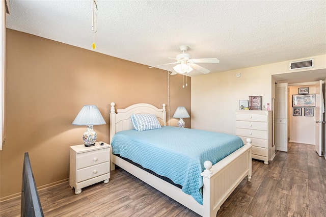 bedroom featuring hardwood / wood-style flooring, ceiling fan, and a textured ceiling