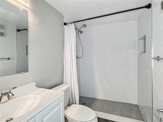 bathroom with vanity, a shower with curtain, a textured ceiling, and toilet