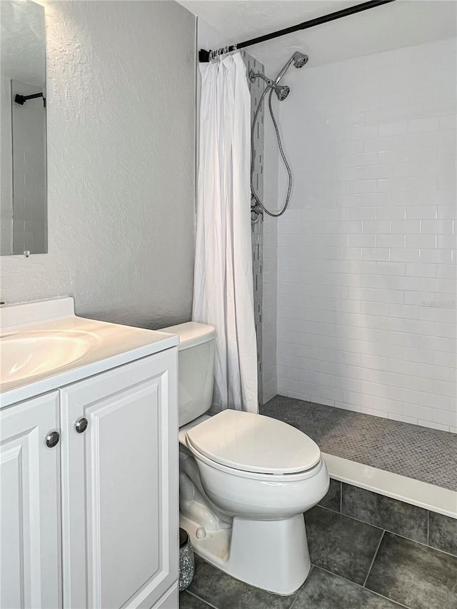 bathroom with curtained shower, vanity, and toilet